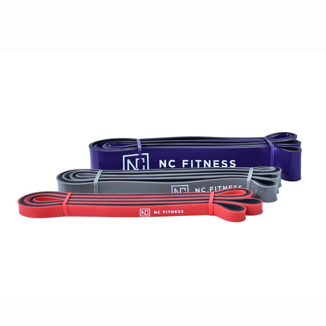 Three resistance bands in purple, grey, and red with NC Fitness logo.