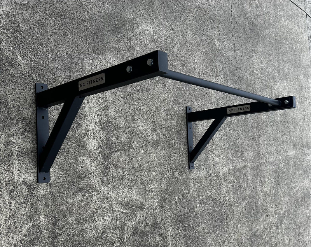 Black heavy-duty wall mounted pull up bar rack for commercial gym training.