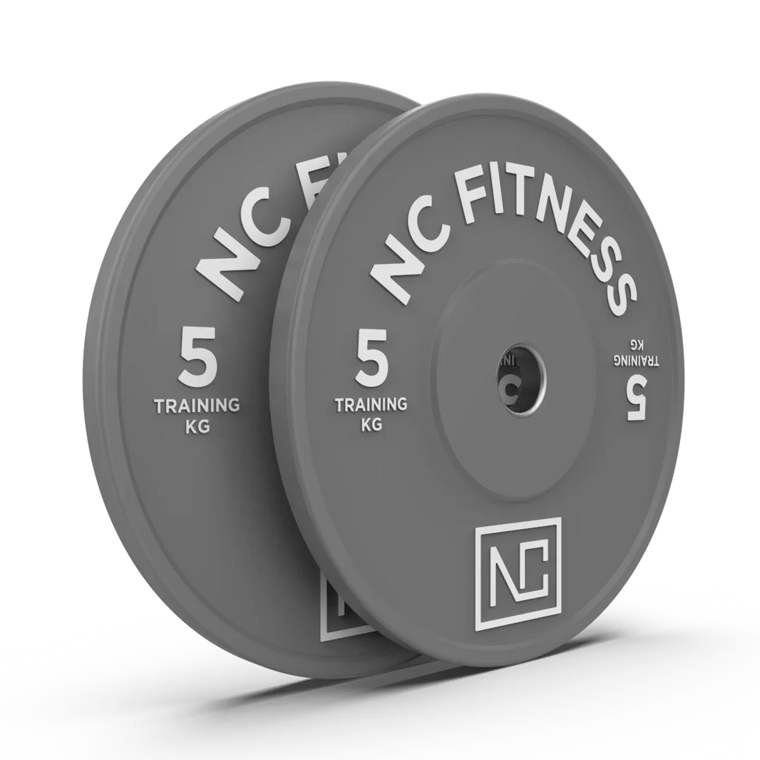 Two grey 5kg NC Fitness training weight plates for gym workouts.