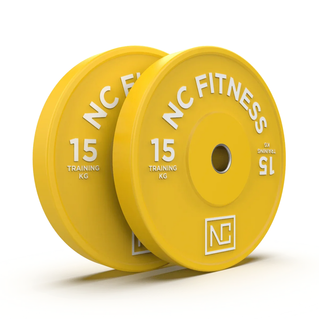 Two yellow 15kg NC Fitness training weight plates for gym workouts.
