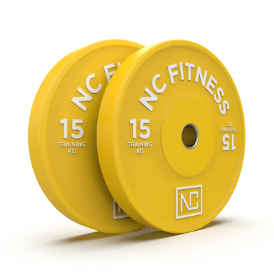 Two yellow 15kg NC Fitness training weight plates for gym workouts.