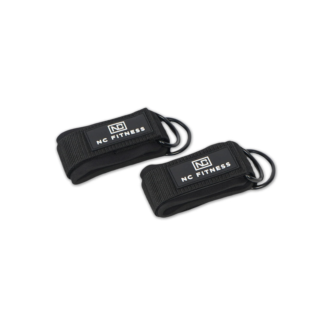 Two black NC Fitness ankle straps with D-ring attachments on a white background