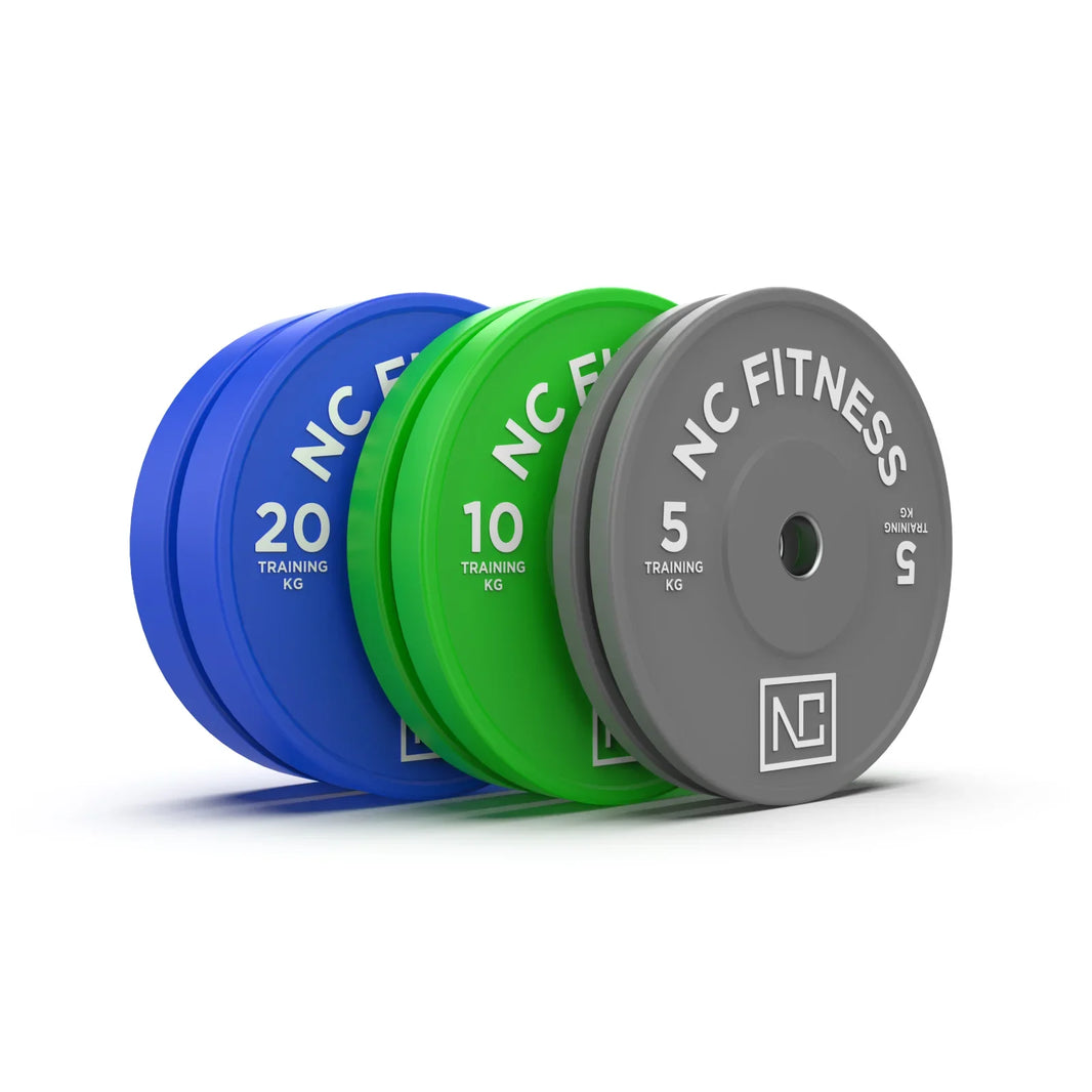 Blue, green, and grey NC Fitness bumper plates weighing 20kg, 10kg, and 5kg.