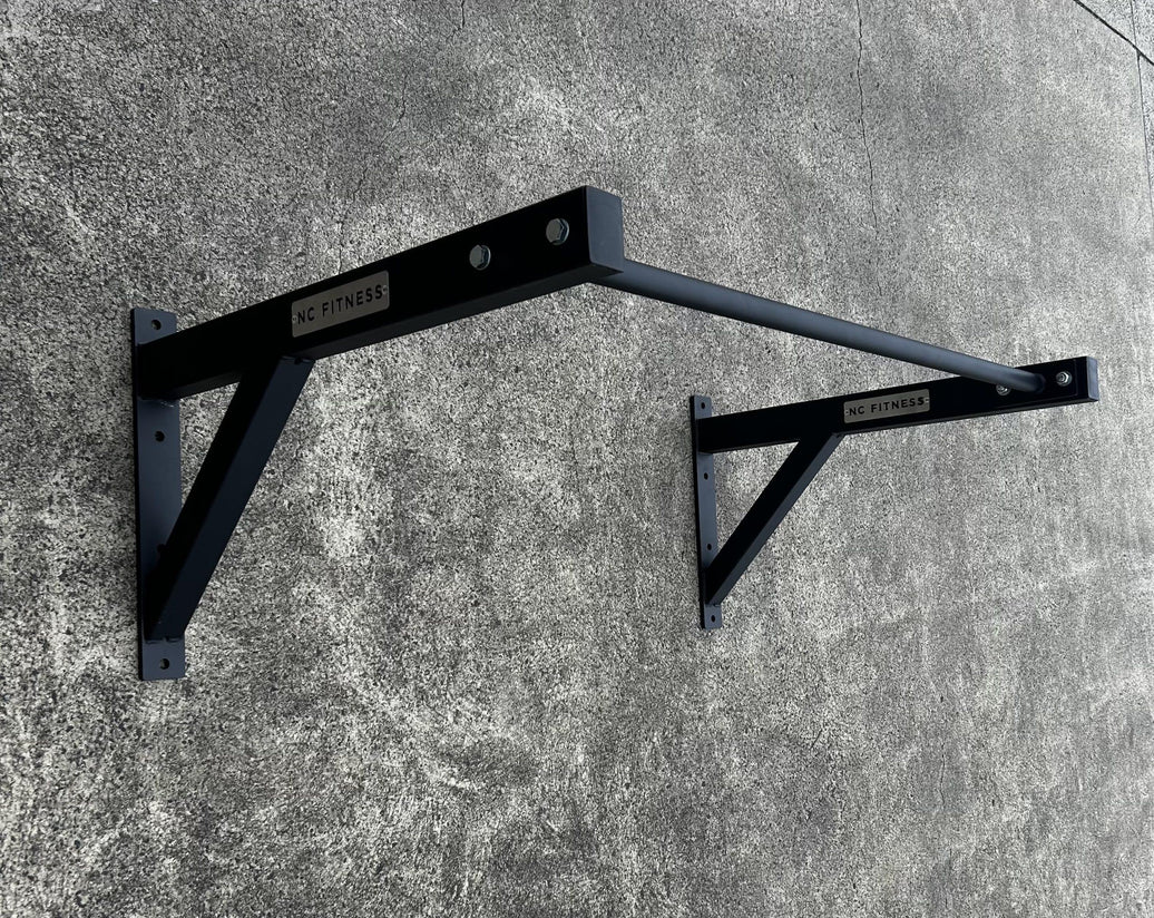 Black heavy-duty wall mounted pull up bar rack for commercial gym training.
